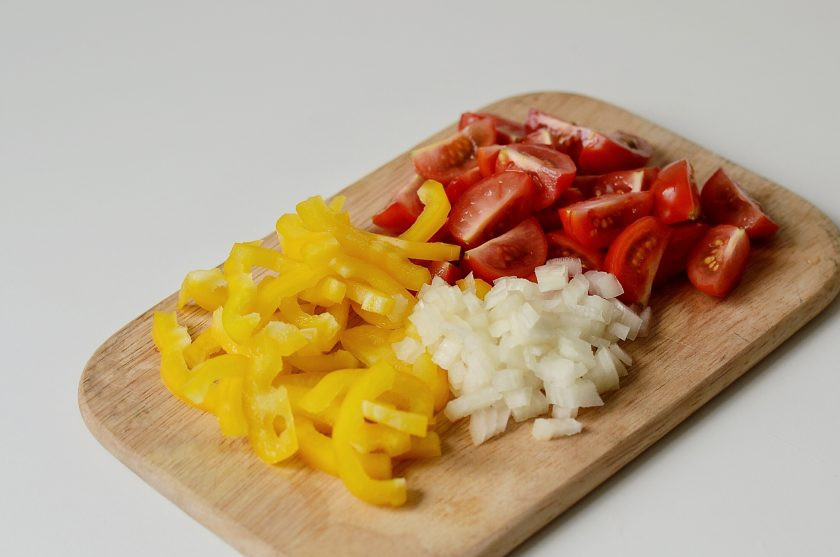 1. Этап. Грузинский салат с баклажанами: Помидоры черри нарежьте четвертинками, болгарский перец полукольцами, лук порубите кубиками.