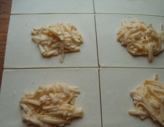 1. Этап. Хачапури с сулугуни в духовке: В центр каждого квадратика из теста выложите сырно-яичную начинку. Следите, чтобы она не попала на край квадратика. Тогда тесто может разойтись в процессе выпекания и начинка вытечет, попадет на противень и будет подгорать.