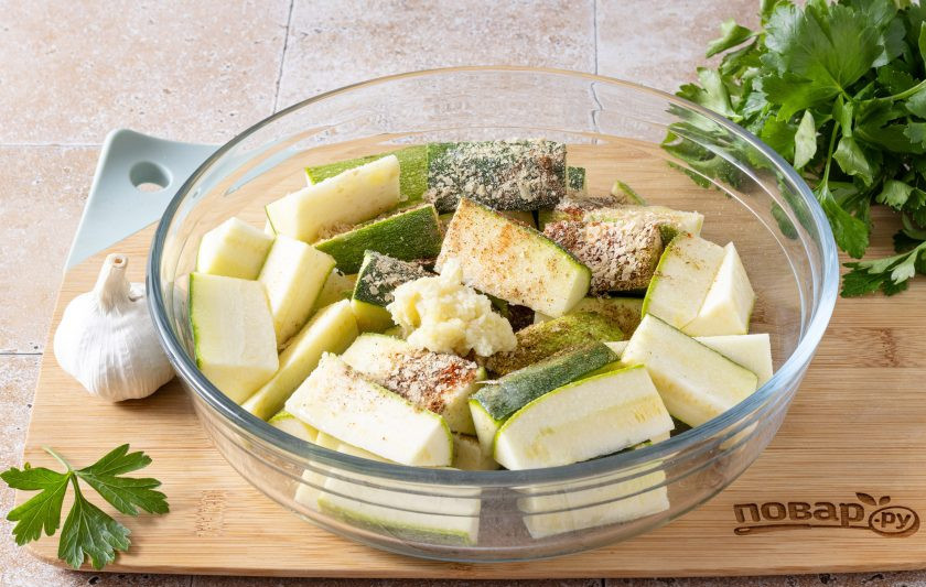 1. Этап. Кабачки с чесноком в духовке: Переложите овощи в глубокую миску, добавьте оливковое масло, все специи, соль и измельченный чеснок.