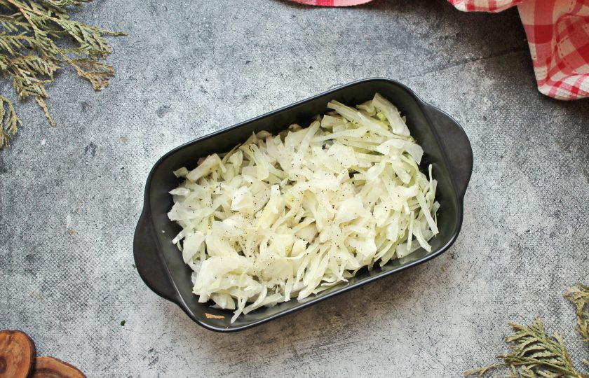 1. Этап. Треска с капустой: Форму для запекания смажьте растительным маслом. Белокочанную капусту порежьте тонкой соломкой и выложите в форму, примните.