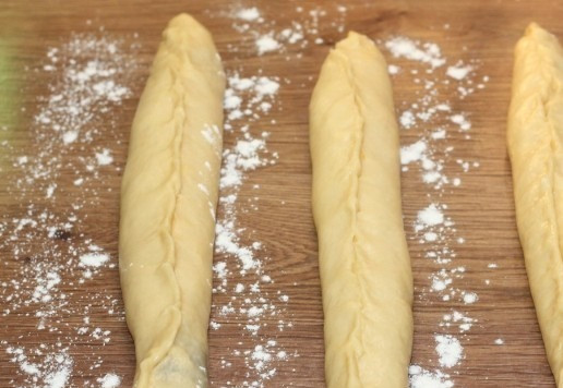 1. Этап. Сдобный пасхальный хлеб с тремя начинками: 15. Аккуратно сворачиваю лепешки в рулет, не растягивая тесто, и защипываю край. Край немного обваливаем в муке.