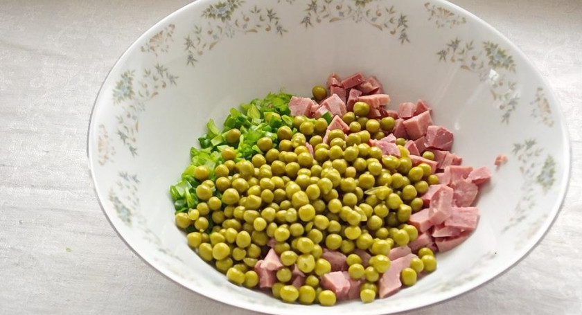 1. Этап. Салат Марсель: 4. Зеленый горошек откинуть на дуршлаг и слить лишнюю жидкость. Слегка просушить. В салатнике соединить ветчину, огурцы, зеленый лук и горошек.