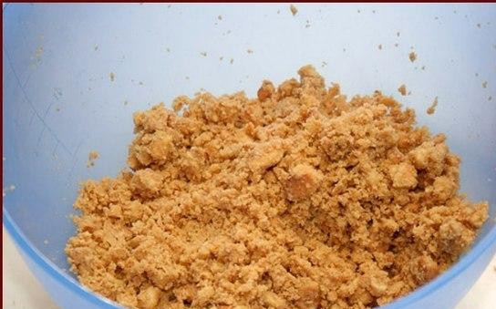 1. Этап. Пирог со сгущенкой: В измельченное печенье добавляем мелко нарубленное холодное сливочное масло. Все хорошенько перемешиваем.