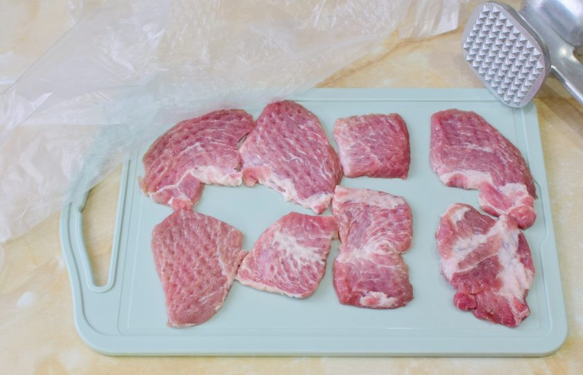 1. Этап. Мясо по-орловски из свинины: Мясо нарежьте небольшими кусочками и отбейте, накрыв пленкой.