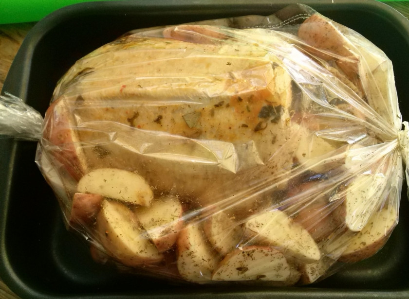 1. Этап. Гусь в рукаве: Гуся пометите в рукав, плотно завязанный с одной стороны. Картофель расположите по бокам птицы. Я люблю картофель, хорошо пропеченный без жира, поэтому часть его кладу сверху гуся. Завяжите плотно рукав с другой стороны и отправляйте в разогретую духовку.