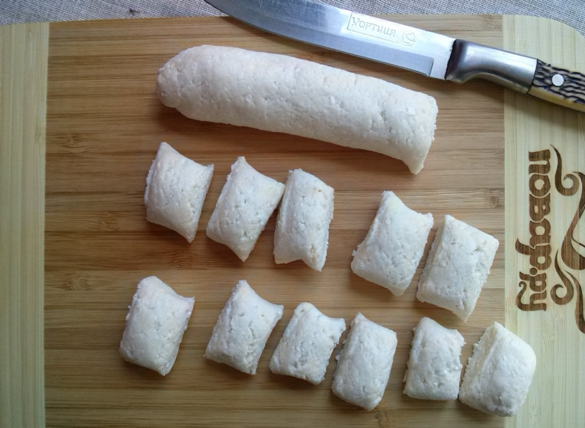 1. Этап. Ленивые вареники из творога: Разделите тесто на две части, из каждой скатайте колбаску, которую затем нарежьте на кусочки.