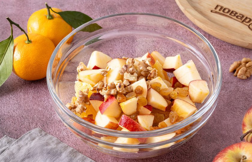 1. Этап. Салат с яблоком, апельсином и мандарином: Грецкие орехи подсушите в сковороде и крупно порубите. Изюм промойте в теплой воде и обсушите с помощью бумажных салфеток. Добавьте в миску орехи и изюм.