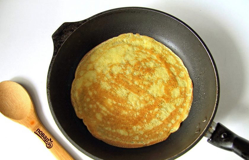 1. Этап. Блины на кипятке без молока: Поставьте сковороду на средней огонь, смажьте ее первый раз маслом и дождитесь пока она хорошо раскалится. Зачерпните половник теста и вылейте его в центр, одновременно вращая сковороду по кругу. Тесто равномерно распределится и получится блинчик. Жарьте его с двух сторон до золотистого цвета.