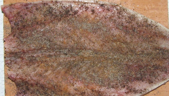 1. Этап. Скумбрия в духовке с картофелем: Теперь ее необходимо обильно посыпать специями для рыбы, перцем и немного посолить.