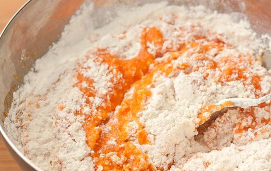 1. Этап. Оладьи из тыквы с сыром: Просеиваем в смесь муку и замешиваем не слишком густое тесто.