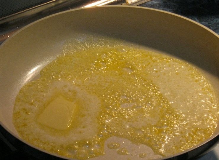 1. Этап. Грибы, фаршированные фаршем: Сковороду разогреваем на огне и растапливаем в ней небольшой кусочек сливочного масла.