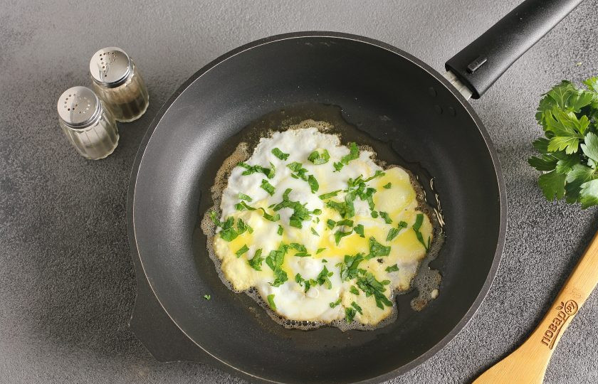 1. Этап. Португальский завтрак: В сковороде растопите кусочек сливочного масла (огонь должен быть небольшой). Разбейте яйцо и сразу же лопаткой нужно аккуратно распределить яйцо по сковороде, так, чтобы желток тоже растёкся. Необходимо довести размер яичной лепешки по площади до размера двух кусочков хлеба, с которым вы будете дальше готовить. Яйцо посолите, поперчите и посыпьте рубленой зеленью.