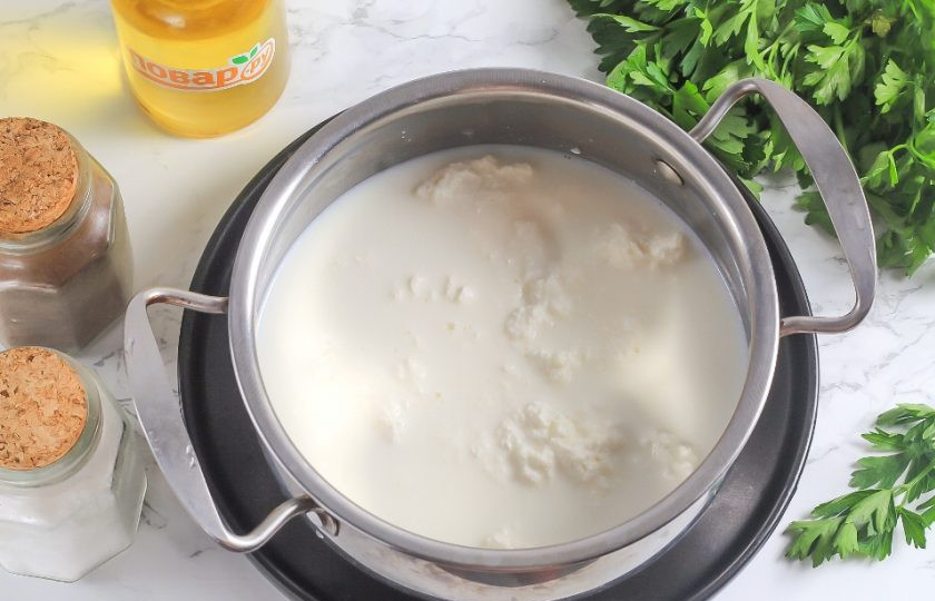 1. Этап. Домашняя брынза из творога: Молоко перелейте в кастрюлю или казан. Выложите туда же творог и всыпьте соль. Поместите емкость на плиту, включая средний нагрев.