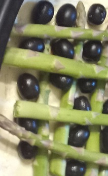 1. Этап. Пирог со спаржей, оливками и яйцами: Разогреть духовку до 220С. В ёмкость для запекания выложить слоёное тесто и с помощью ножа сделайте надрезы по всему периметру теста, отступая 2,5 см от границы. Смазать тесто сливочным маслом (или по желанию сливочным сыром) и выложите маслины на поверхность. К маслинам добавить спаржу в произвольном порядке.