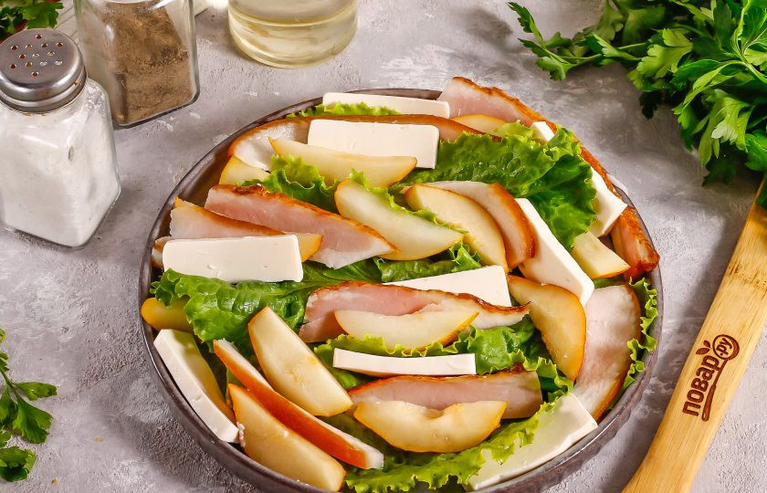 1. Этап. Салат с грушей и беконом: Плавленый сырок очистите от фольги, нарежьте ломтиками и добавьте к остальным нарезкам.