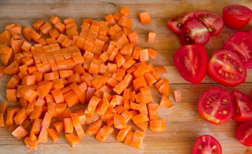 1. Этап. Салат с морковью: Морковь очистите, промойте и нарежьте мелкими кубиками. Томаты разделите на половинки или четвертинки.