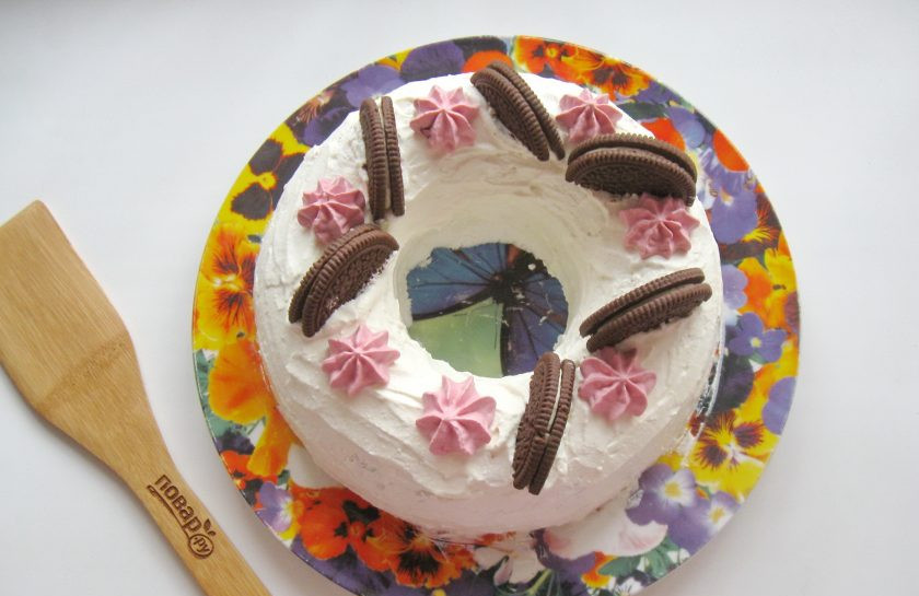 1. Этап. Десерт Новогодний венок: После украсьте десерт по своему вкусу. Я украсила печеньем, разноцветными конфетами, листочками мяты и розочками из остатков творога, в который добавила пищевой краситель. Посыпала сахарной пудрой.