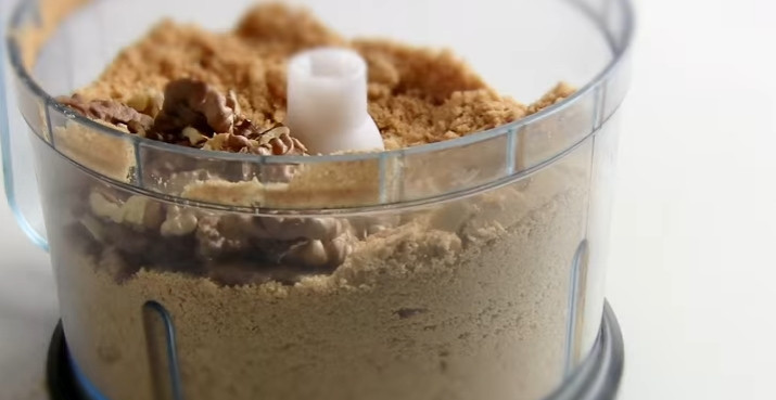 1. Этап. Чизкейк Карамельный по-домашнему со сгущенкой: 1. Песочное печенье перебейте блендером в крошку. Добавьте грецкие орехи, доведите всё до однородной консистенции.