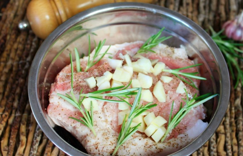 1. Этап. Свиная корейка с розмарином и чесноком в духовке: Добавляем чеснок и розмарин. Чеснок предварительно чистим и режем на кусочки. Все перемешиваем, прижимая, оставляем на 15 минут.