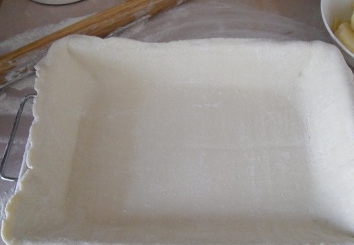 1. Этап. Пирог с мясом из слоеного дрожжевого теста: Разморозьте слоеное тесто. Сначала раскатайте один из двух пластов, а затем поместите его на противень. Тесто можно приготовить самостоятельно, но гораздо удобнее использовать уже готовое из магазина.