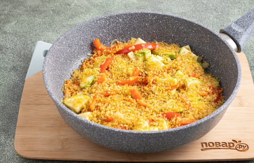 1. Этап. Булгур с кабачками, сладким перцем и фасолью: Затем добавьте булгур. Промывать его не нужно. Обжарьте с овощами булгур еще 1-2 минуты.
