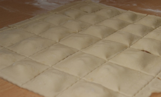 1. Этап. Равиоли с ветчиной: Аккуратно накройте начинку слоем теста, нарежьте равиоли на равные кусочки. Хорошо сдавите края.