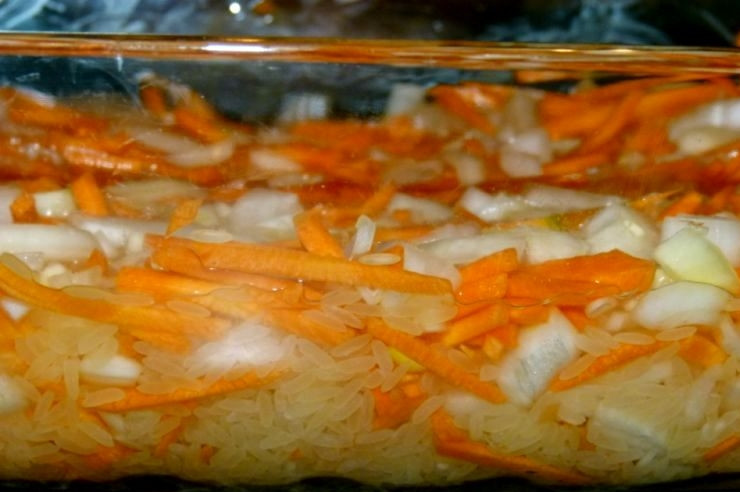 1. Этап. Плов в духовке с курицей: Теперь необходимо влить воду так, чтобы жидкость была на одном уровне с овощами и рисом. Солим и приправляем специями.