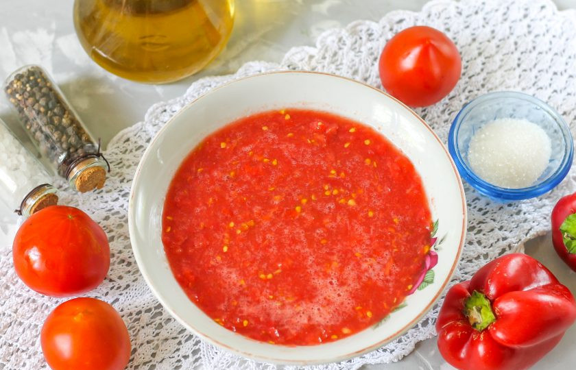 1. Этап. Ленивое лечо: Помидоры промойте в воде, разрежьте каждый плод пополам и вырежьте зеленые сердцевинки. Протрите половинки на терке с крупными или мелкими ячейками в миску. Жмых удалите.