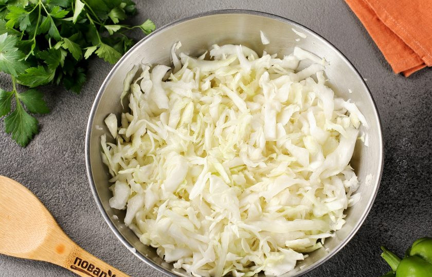 1. Этап. Тушёная капуста с мясом в кастрюле: Капусту нашинкуйте, добавьте щепотку соли и помните руками. Так капуста пустит сок и станет мягче.