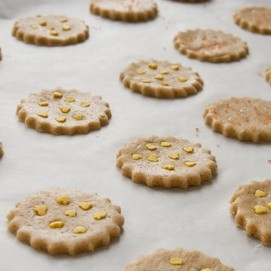 1. Этап. Классическое имбирное печенье: Раскатываем тесто в достаточно тонкий пласт. Вырезаем из пласта печенье (форма - какая вам больше нравится). Если есть желание, печенье можно украсить измельченным миндалем или присыпать сахаром. Выкладываем печенье на противень, застланный пергаментной бумагой.