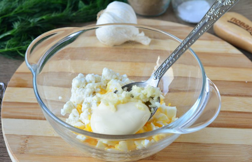 1. Этап. Крабовые палочки фаршированные творогом: В начинку выдавите чеснок, добавьте майонез. Слегка посолите и поперчите.