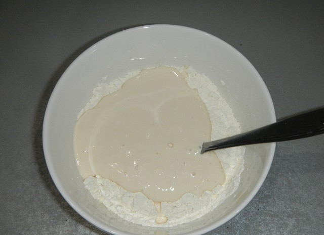 1. Этап. Оладьи на простокваше: Добавьте простоквашу и замесите средней густоты тесто.