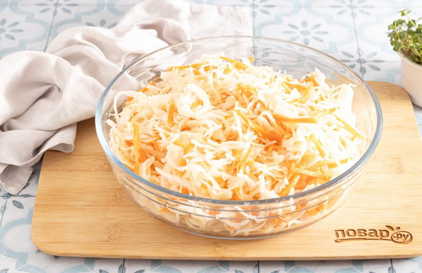 1. Этап. Квашеная капуста классическая в банке: Добавьте соль. Обомните руками капусту с морковью и тщательно перемешайте, чтобы соль растворилась, а капуста дала сок.