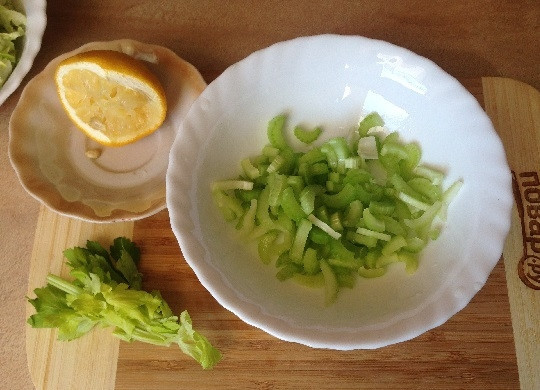 1. Этап. Свежий салат с сельдереем, яблоком и клюквой: 2. Стебли сельдерея нарежем на тонкие ломтики, добавим к ним лимонный сок, перемешиваем.