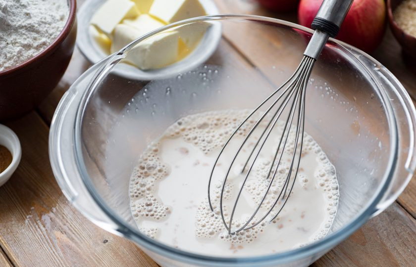 1. Этап. Булочки с яблоком и корицей из дрожжевого теста: Залейте все теплым молоком и хорошенько перемешайте венчиком до растворения дрожжей.