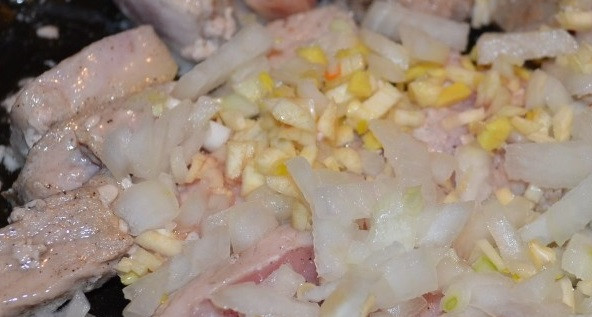 1. Этап. Чахохбили из свинины: К мясу добавьте мелко порезанные лук и чеснок. Жарьте еще 5 минут, помешивая.
