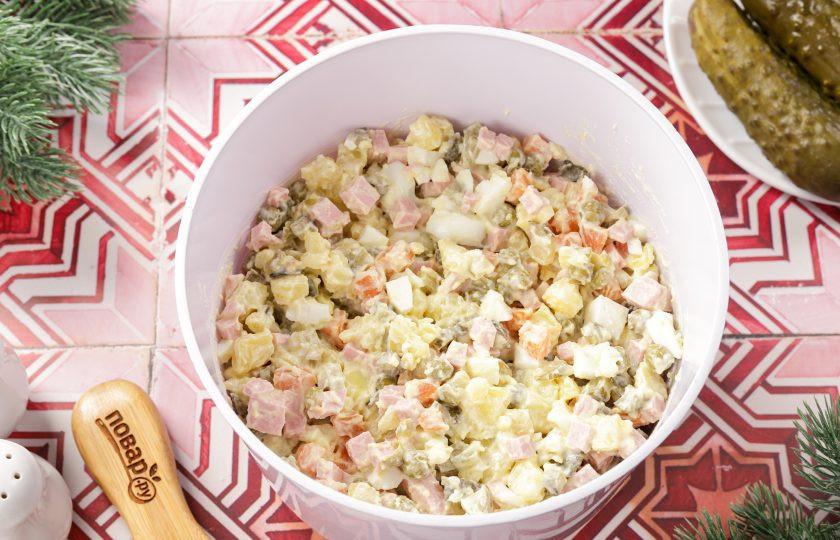 1. Этап. Салат Оливье на год Змеи: Заправьте салат майонезом, посолите по вкусу и тщательно перемешайте.