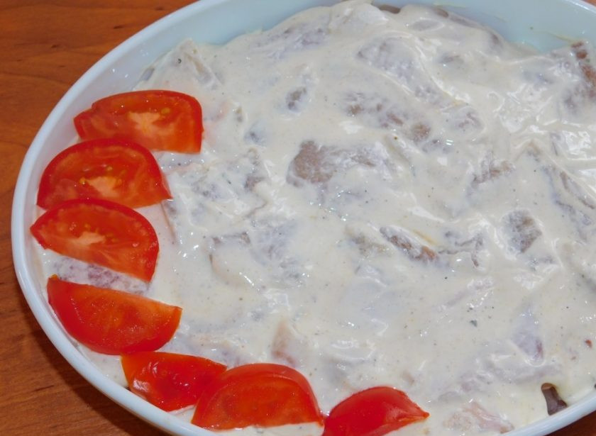 1. Этап. Рыба с овощами под сыром: На овощи выложите нарезанное филе пангасиуса и смажьте сметанным соусом. Сверху разложите нарезанные помидоры.