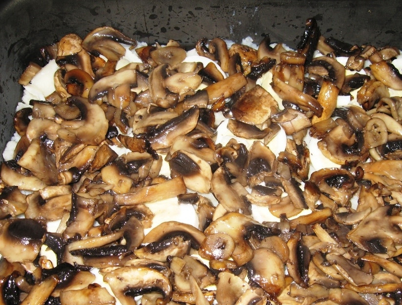 1. Этап. Запеканка из картофельного пюре с грибами: Когда грибочки обжарятся до нужного оттенка, снимите их с огня, дайте им немного остыть. Выложите шампиньоны поверх картофельного пюре и яиц, разровняйте слой. Снова посолите и поперчите блюдо по вкусу.