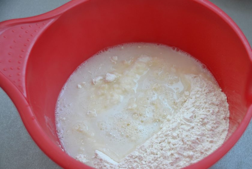 1. Этап. Чебуреки Мини: Просеянную муку всыпьте в емкость для замеса теста, влейте к муке стакан кипятка, смешайте муку с водой.