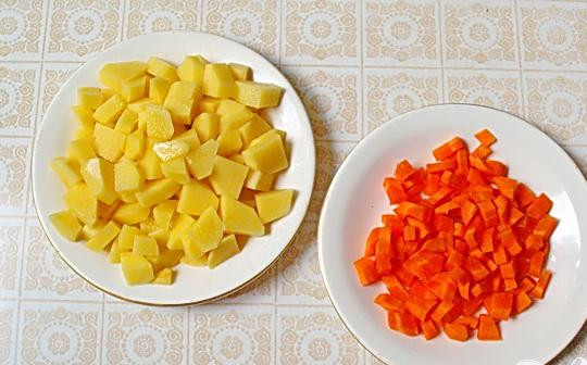 1. Этап. Солянка с ветчиной и грудинкой: 1. Сварим куриный бульон. Когда бульон сварили, почистим картофель и морковь. Все нарезаем кубиками: картофель режем крупными кусочками, а морковь нарезаем мелкими. Опускаем морковь в кипящий бульон, немного огонь уменьшаем, и минуты через две добавляем туда картофель.