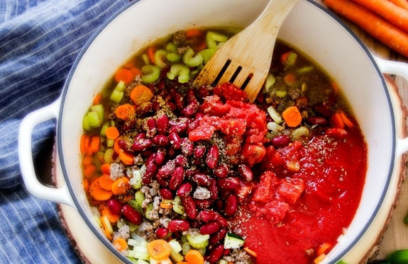 1. Этап. Итальянский обед: 2. Отправьте кастрюлю на огонь, добавьте фасоль (слейте воду), консервированные томаты (свежие), томатный соус. Влейте воду и бульон, а также посолите и поперчите, добавьте все специи по вкусу (примерно по 1 чайной ложке каждой). Варите суп после закипания 15 минут.