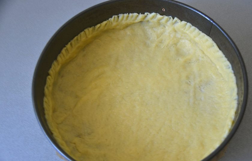 1. Этап. Грушевый пирог с карамельной заливкой: Распределите тесто по форме, сделайте достаточно высокие бортики. Это можно сделать руками, а можно раскатав скалкой между двумя слоями пленки и перенеся его в форму. Поставьте заготовку в морозилку на 30 минут.