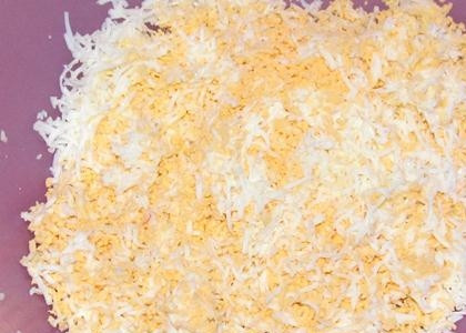 1. Этап. Крабовый салат без риса с огурцом: Добавляем к остальным ингредиентам консервированную кукурузу. Яйца натираем на терке либо мелко рубим ножом. Теперь добавляем специи и майонез и хорошенько все перемешиваем.