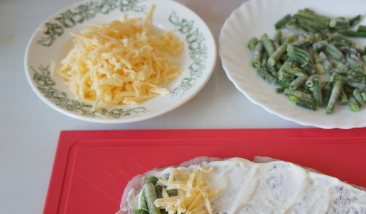 1. Этап. Рулетики из индейки с фасолью: Солим, перчим по вкусу. Смазываем смесью из сметаны и горчицы. Кладём несколько стручков фасоли и тёртый сыр на край стейка. Сворачиваем в рулет. Немного сыра оставляем, пригодится в конце готовки.