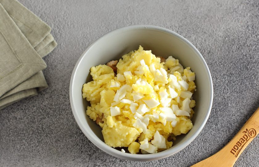 1. Этап. Невесткин пирог: Добавьте картофельное пюре и нарезанное кубиками вареное яйцо.