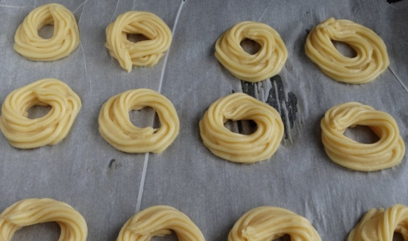 1. Этап. Заварные кольца: 5. Противень застилаем пергаментом и с помощью кондитерского мешка выдавливаем тесто в форме колец.