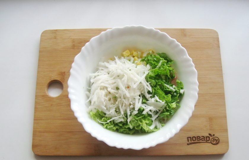 1. Этап. Салат с дайконом и крабовыми палочками: Дайкон помойте, очистите, натрите на терке и выложите в салат.
