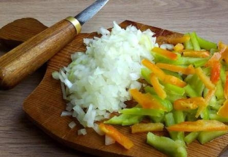 1. Этап. Куриная грудка в кисло-сладком соусе: Тем временем очистим лук от шелухи, нарежем его мелко. Перец, помытый и очищенный от семян, порежем соломкой.