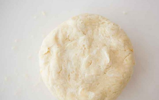 1. Этап. Тесто со сметаной для пирога: Выложите тесто на стол и месите руками. Если оно прилипает к рукам, посыпьте мукой. Оберните плотно пластиковой пленкой и охладите в холодильнике час. Если же вы готовите тесто заблаговременно, оберните его фольгой и заморозьте.